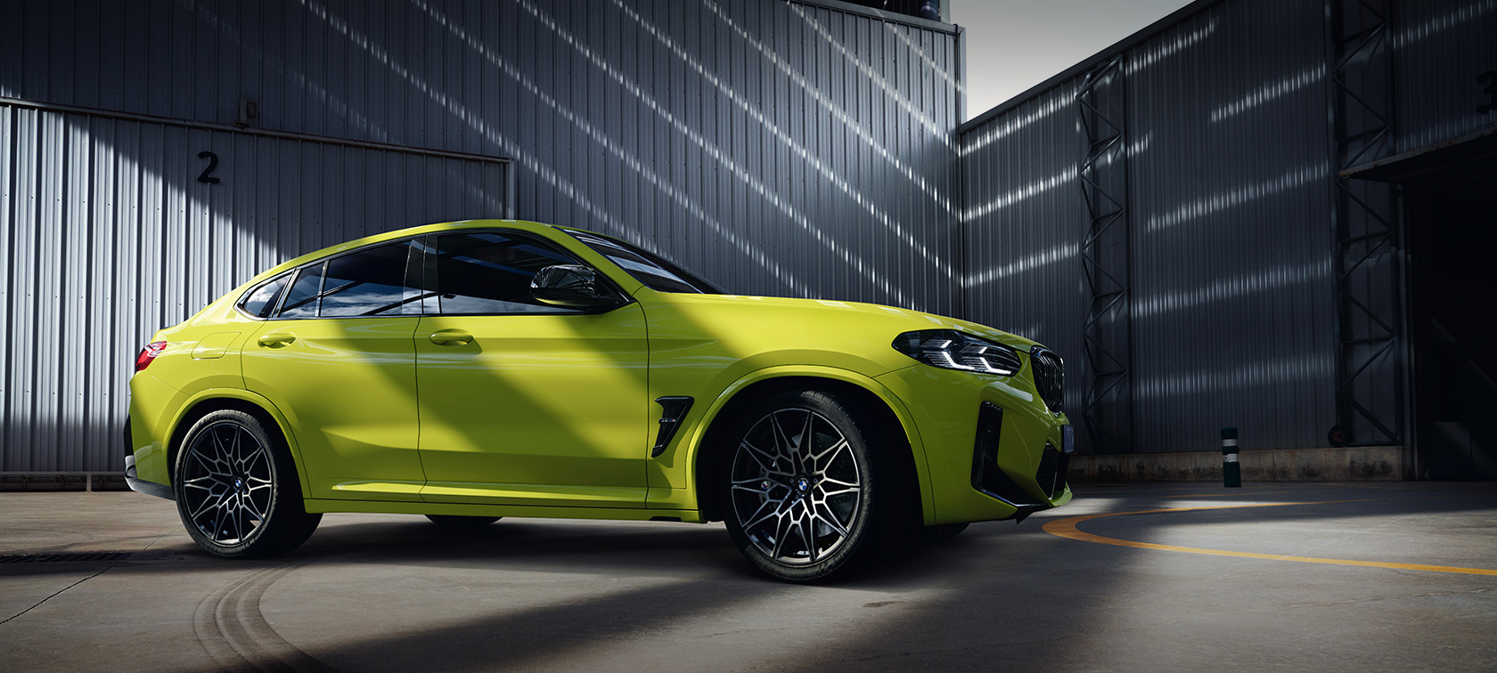 BMW X4 M Competition F98 LCI Renovación 2021 Sao Paulo Gelb Vista lateral en un pabellón