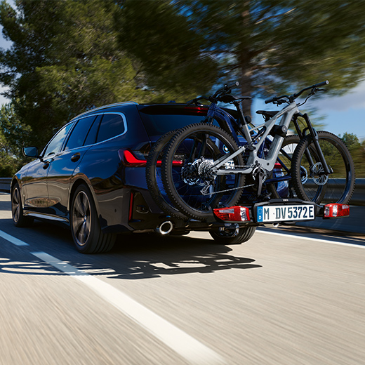 BMW Serie 3 Touring G21 PHEV Vista de 3/4 de la zaga con bicicletas, en marcha