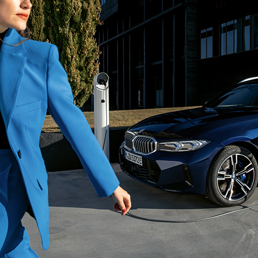 Situación de carga con BMW, mujer caminando en primer plano